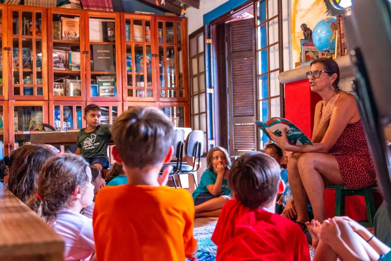 Professora realizando atividade de leitura com estudantes do Colégio São João Ilhabela.